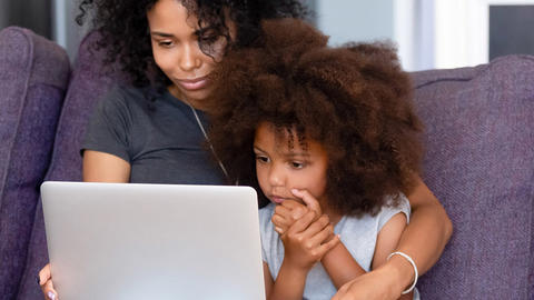 Mom and daughter on couch with computer