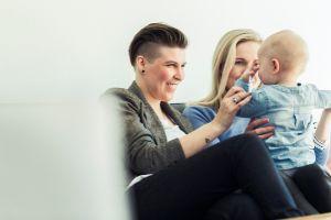 Same Sex Female Couple Smiling at Baby