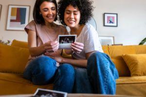 Same Sex Female Couple Looking at Baby Ultrasound and Smiling