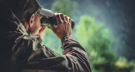Man with binoculars in the woods