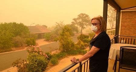 Women on balcony with N95 mask on looking at the wildfire smoke