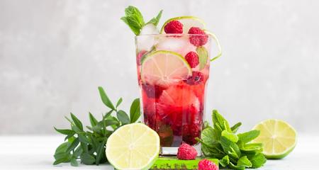 Glass of razzmint mocktail with ice, lime and mint leaves