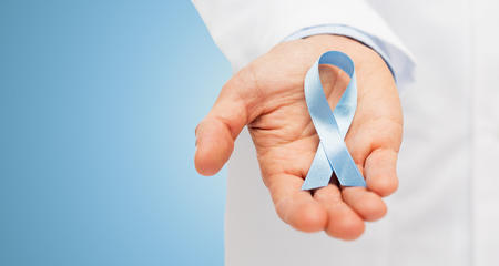 Hand holding prostate cancer awareness ribbon.