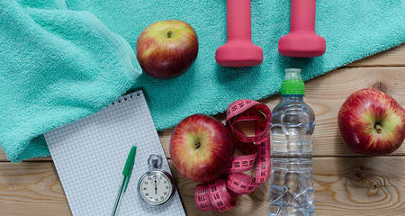 Exercise equipment, apples, timer and a workout towel.