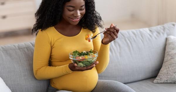 Pregnant Woman Eating Salad for Reproductive Health